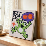 Screaming halloween frog punch needle artwork displayed on a table