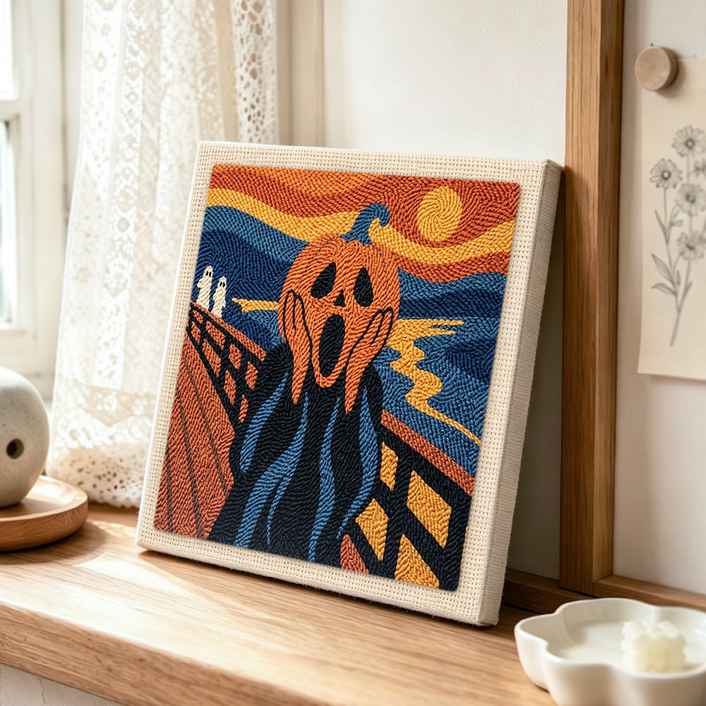 Screaming pumpkin art punch needle artwork displayed on a table