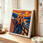 Screaming pumpkin art punch needle artwork displayed on a table