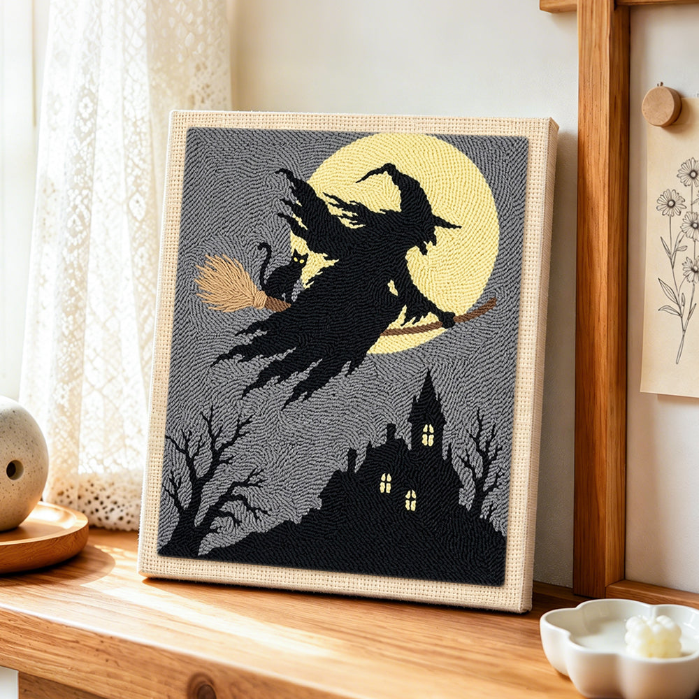 Silhouette witch flying punch needle artwork displayed on a table