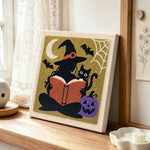 Silhouette witch reading book punch needle artwork displayed on a table