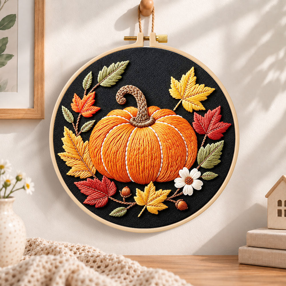 Single pumpkin on black fabric embroidery hoop wall art displayed as warm and cozy handmade home decor