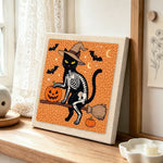 Skeleton cat on broomstick punch needle artwork displayed on a table