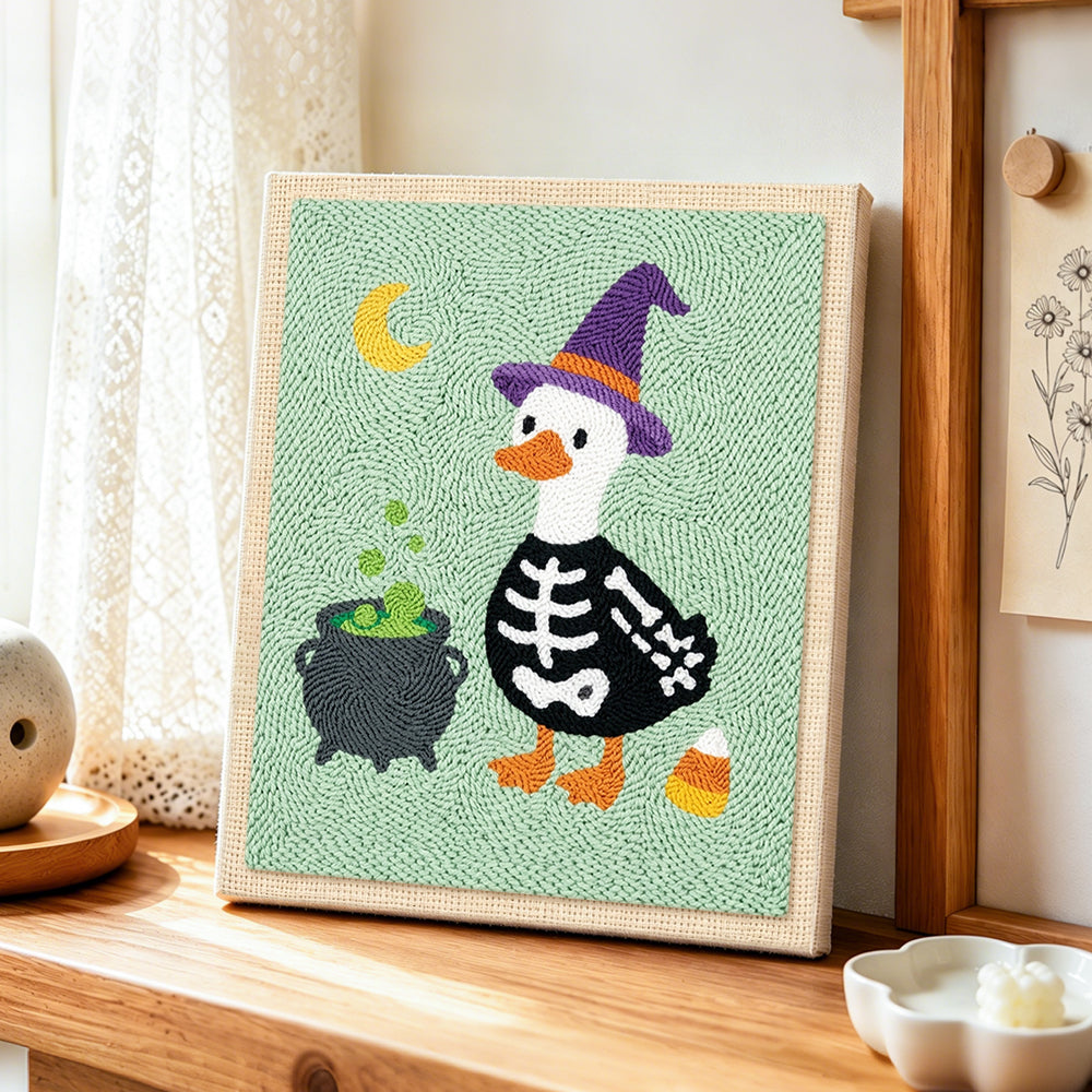 Skeleton duck with witch hat punch needle artwork displayed on a table