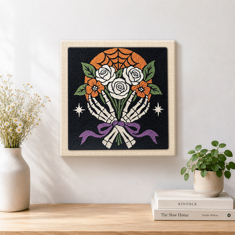 Finished skeleton hands holding roses artwork displayed on a wall