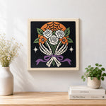 Finished skeleton hands holding roses artwork displayed on a wall