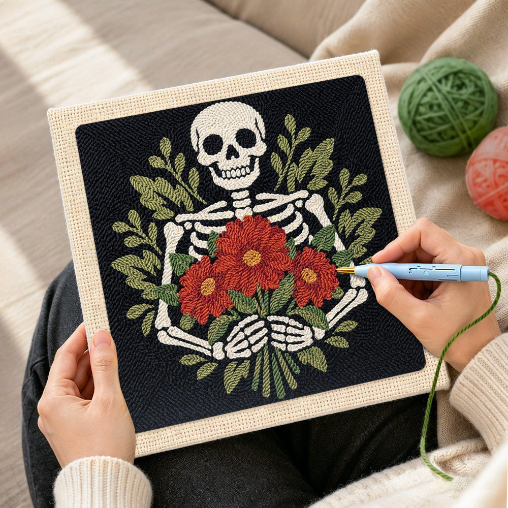 Creating handmade skeleton holding red blooms punch needle artwork