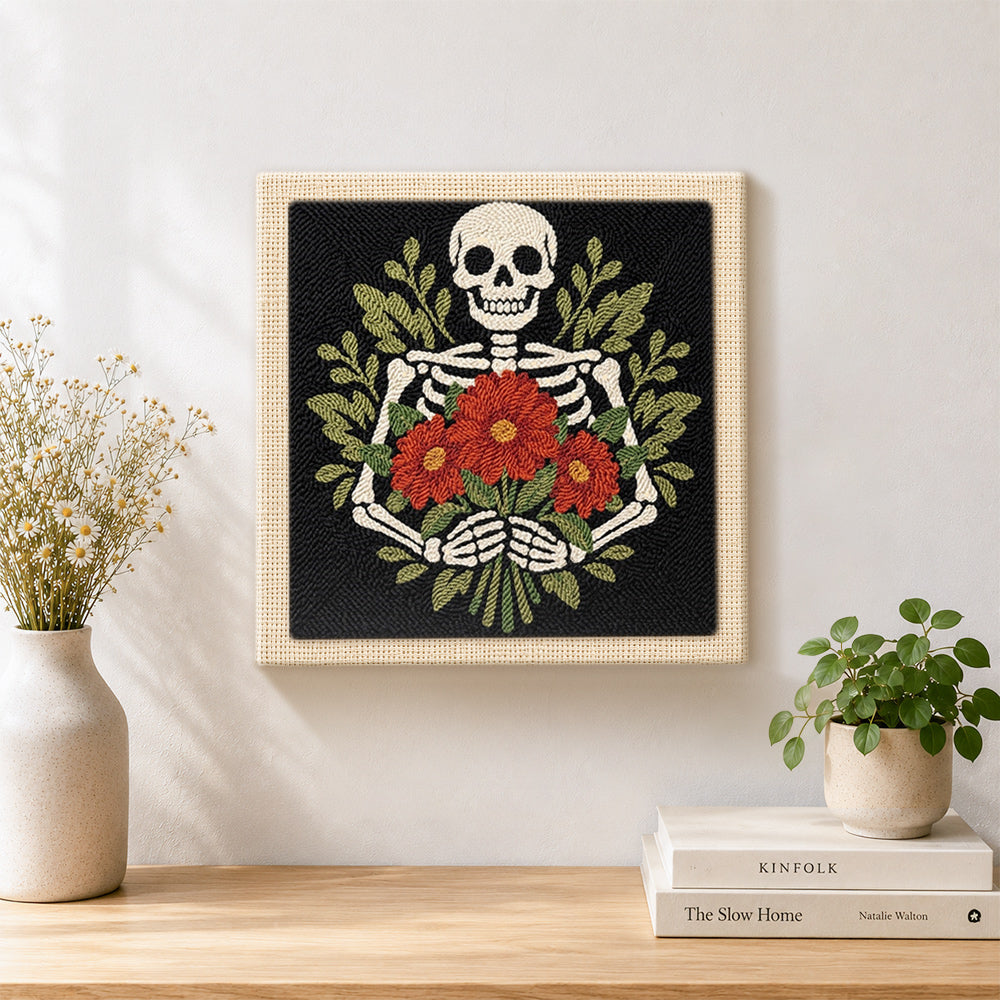 Finished skeleton holding red blooms artwork displayed on a wall