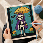 Creating handmade skeleton holding yellow umbrella punch needle artwork