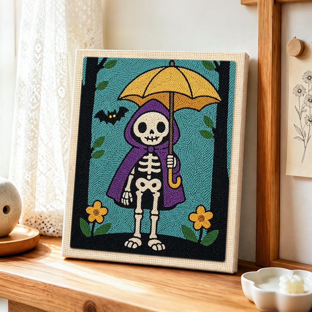 Skeleton holding yellow umbrella punch needle artwork displayed on a table