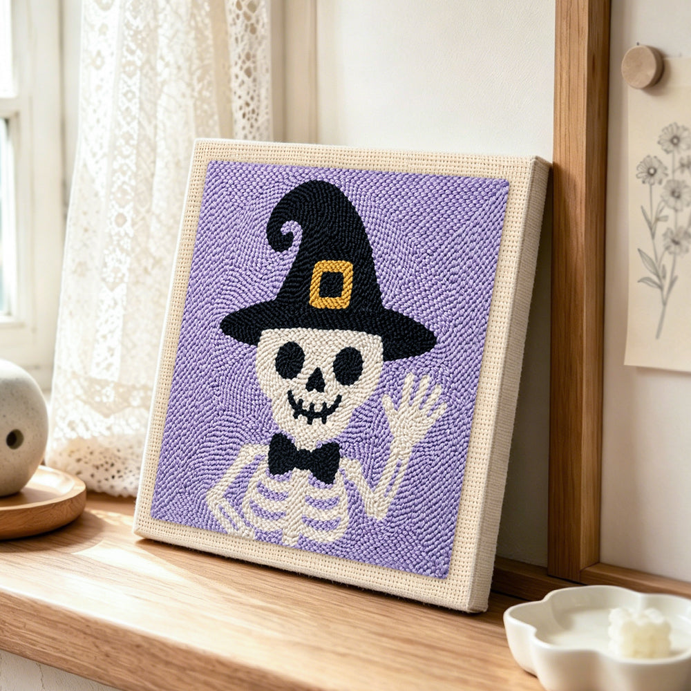 Skeleton in witch hat punch needle artwork displayed on a table