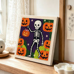 Skeleton pumpkin walk punch needle artwork displayed on a table