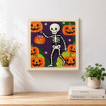 Finished skeleton pumpkin walk artwork displayed on a wall