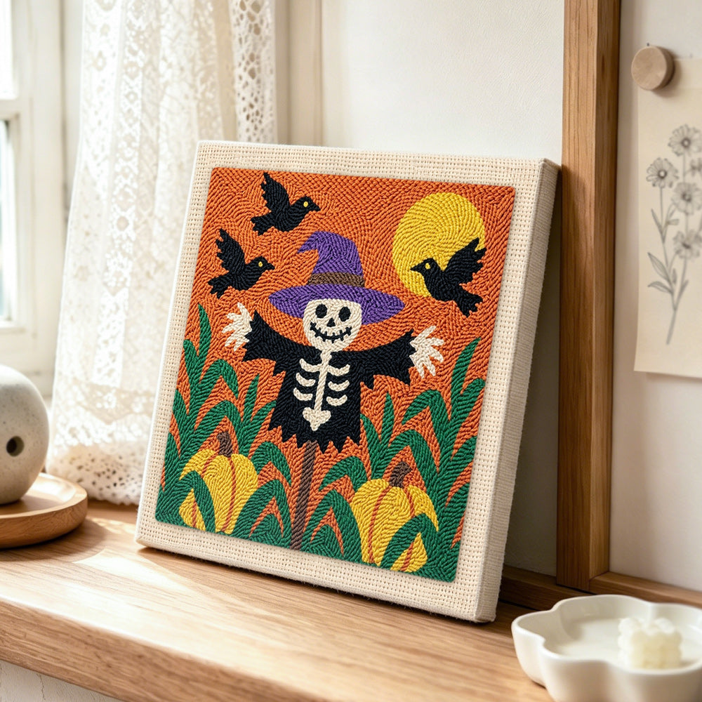 Skeleton scarecrow in pumpkin field punch needle artwork displayed on a table