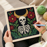 Creating handmade skeleton surrounded by red blooms punch needle artwork