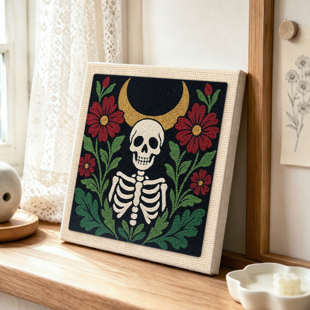 Skeleton surrounded by red blooms punch needle artwork displayed on a table
