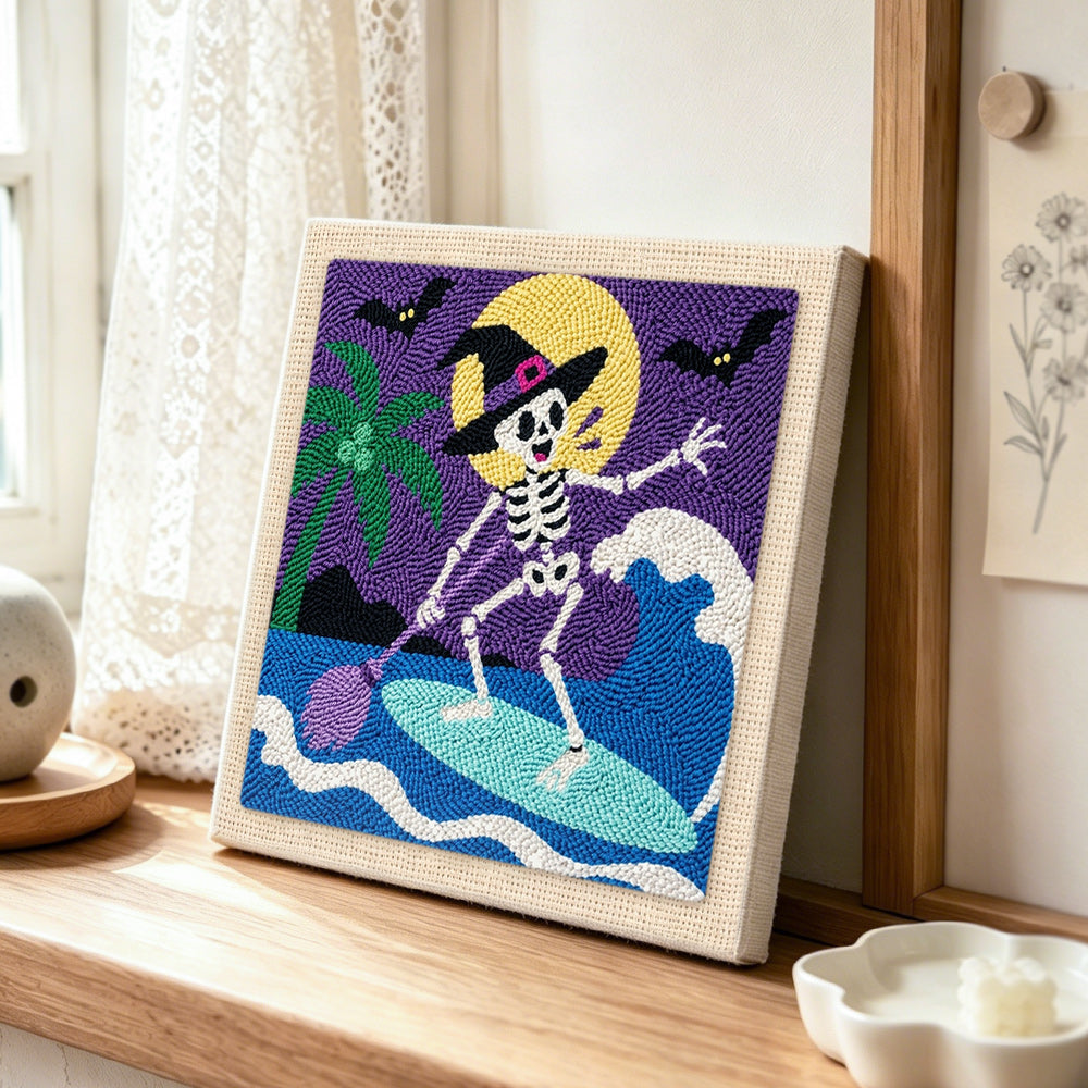 Skeleton witch paddle surfing punch needle artwork displayed on a table