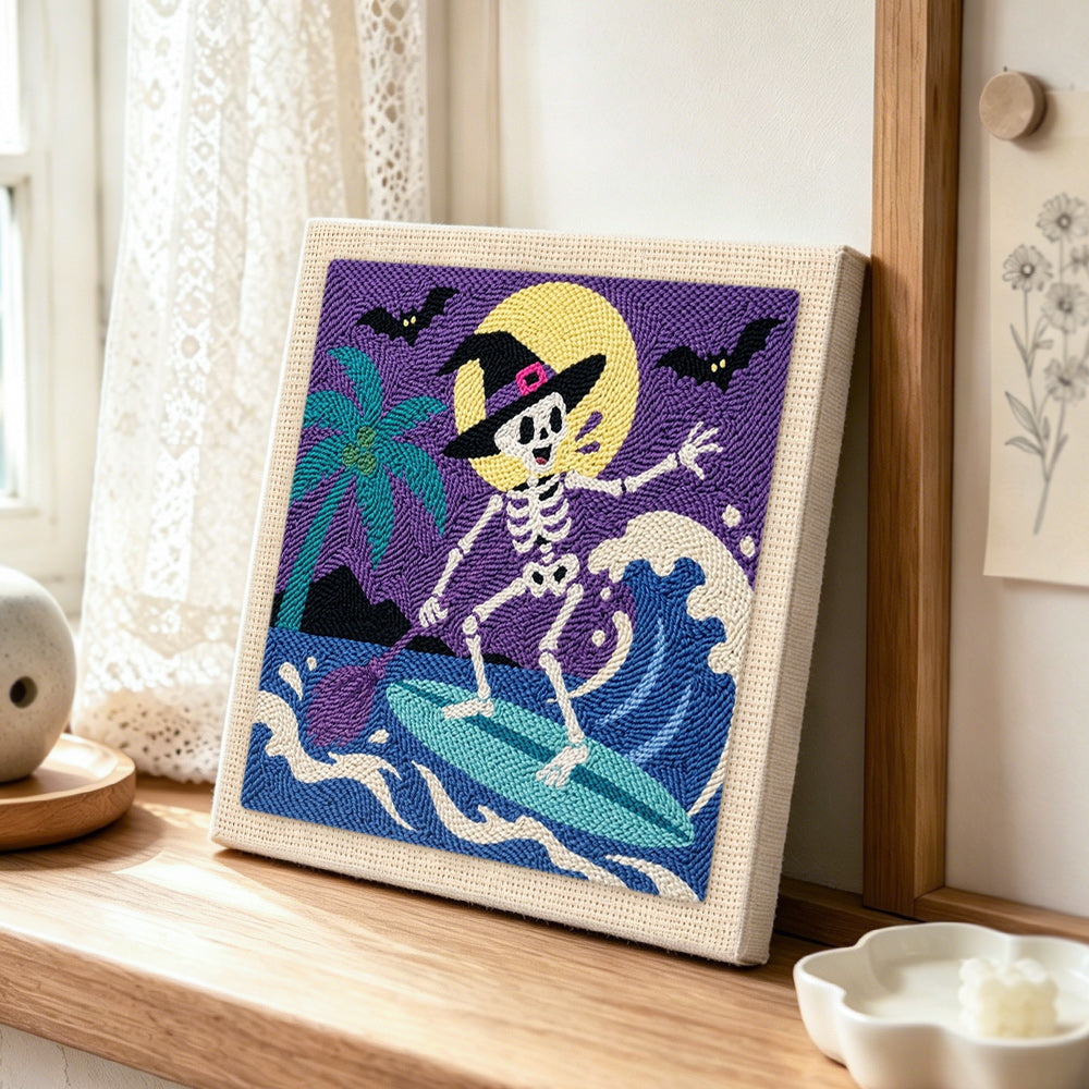 Skeleton witch surfing waves punch needle artwork displayed on a table