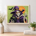 Finished skeleton witch with cauldron artwork displayed on a wall