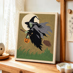 Skeleton witch with pumpkin lantern punch needle artwork displayed on a table