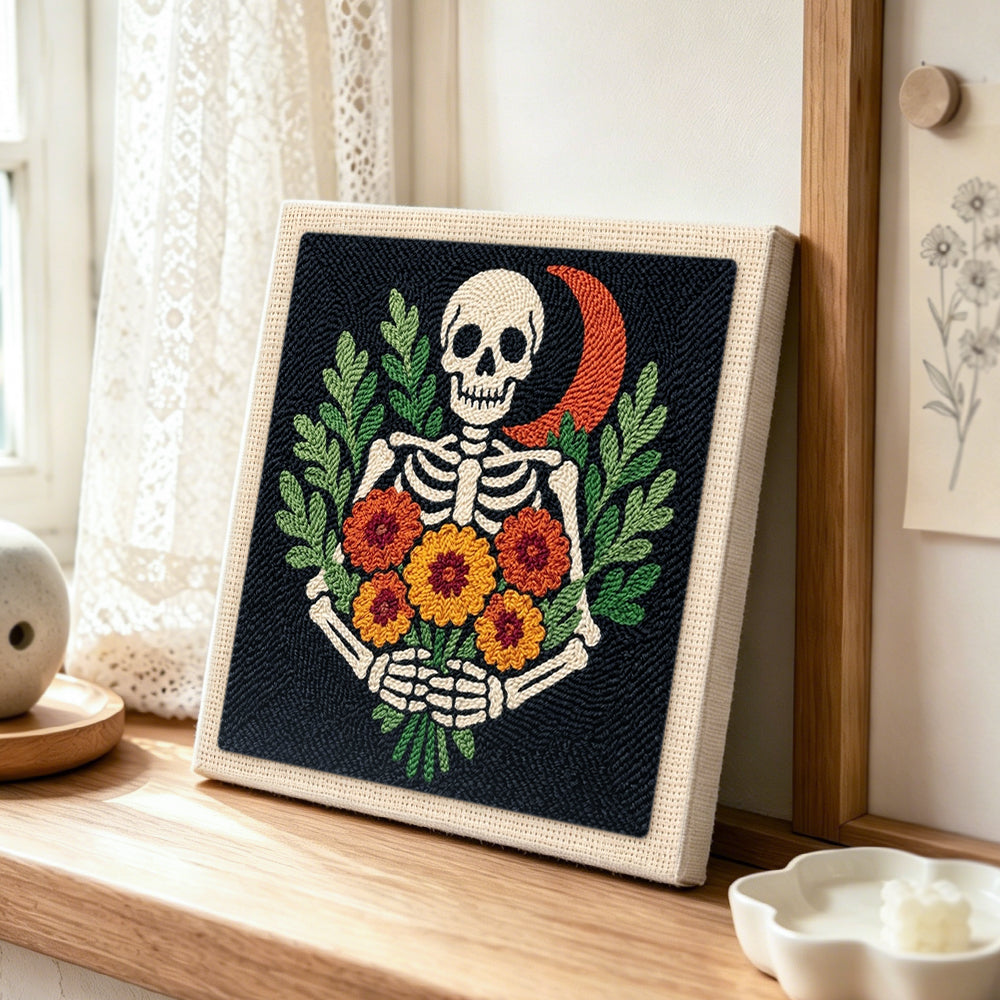 Skeleton with marigolds punch needle artwork displayed on a table