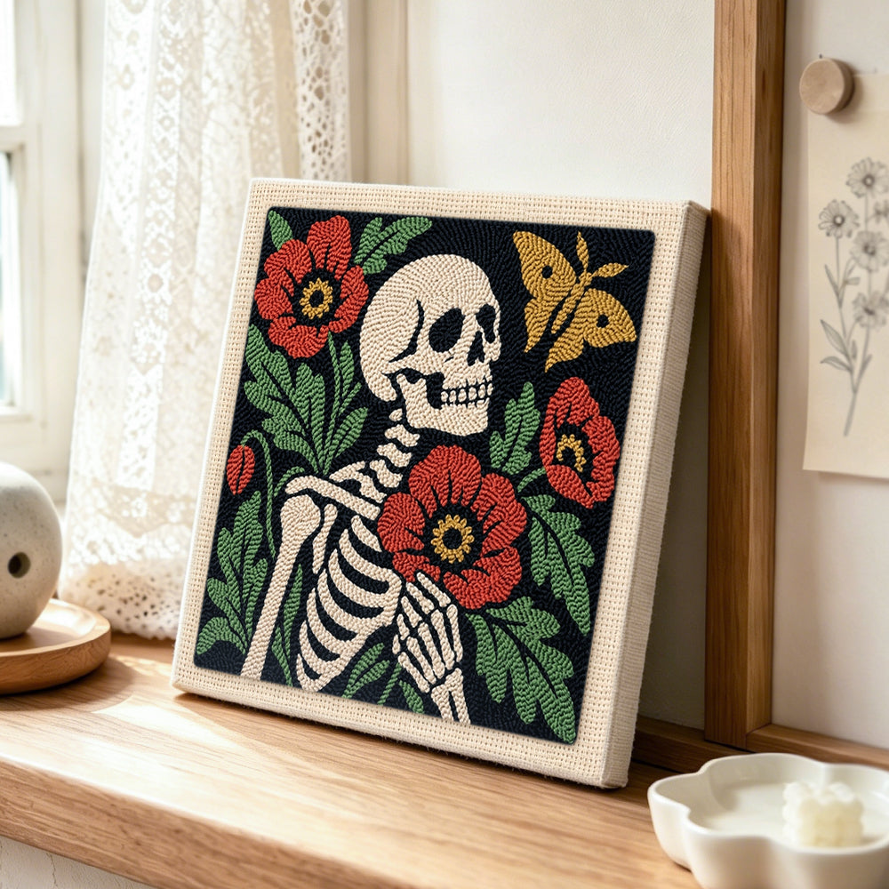Skeleton with poppies and butterfly punch needle artwork displayed on a table
