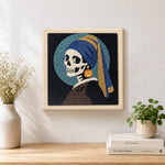 Finished skeleton with pumpkin earring artwork displayed on a wall