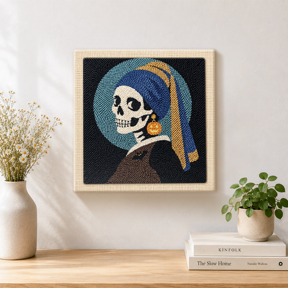 Finished skeleton with pumpkin earring artwork displayed on a wall