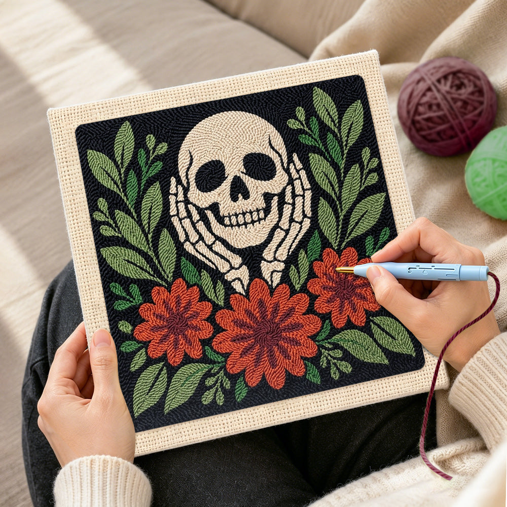 Creating handmade skull cupping cheeks with autumn blooms punch needle artwork
