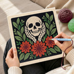 Creating handmade skull cupping cheeks with autumn blooms punch needle artwork