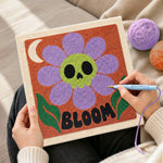 Creating handmade skull flower bloom punch needle artwork