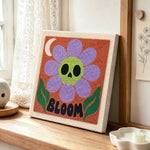 Skull flower bloom punch needle artwork displayed on a table