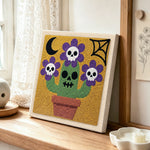 Skull flower cactus punch needle artwork displayed on a table