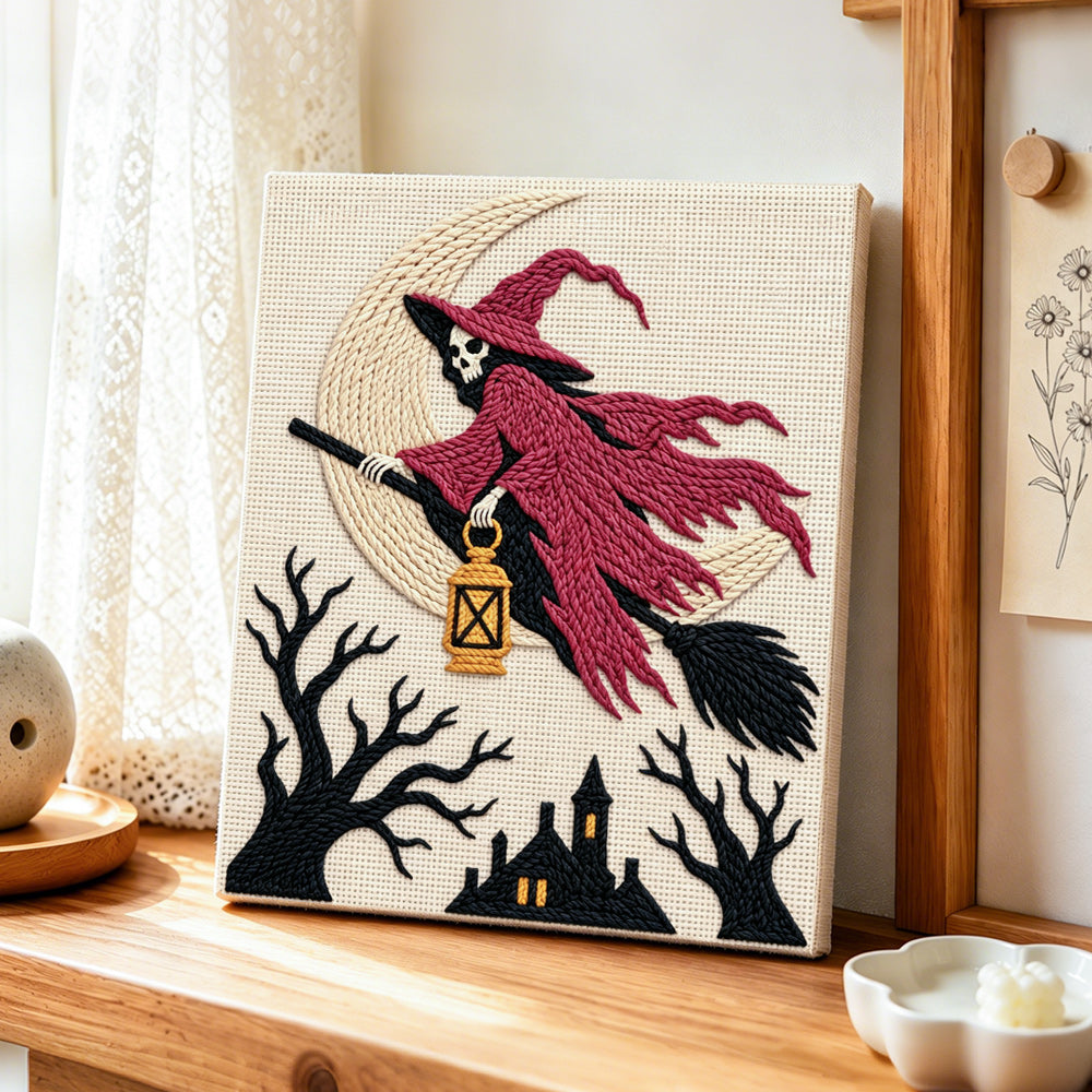 Skull witch on broom punch needle artwork displayed on a table