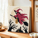 Skull witch on broom punch needle artwork displayed on a table