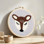 Sleeping deer punch needle artwork displayed on a table