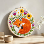 Sleeping fox among the flowers punch needle artwork displayed on a table
