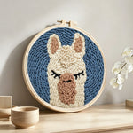 Sleepy alpaca punch needle artwork displayed on a table