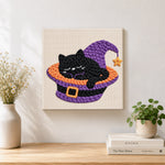 Finished sleepy black witch cat artwork displayed on a wall