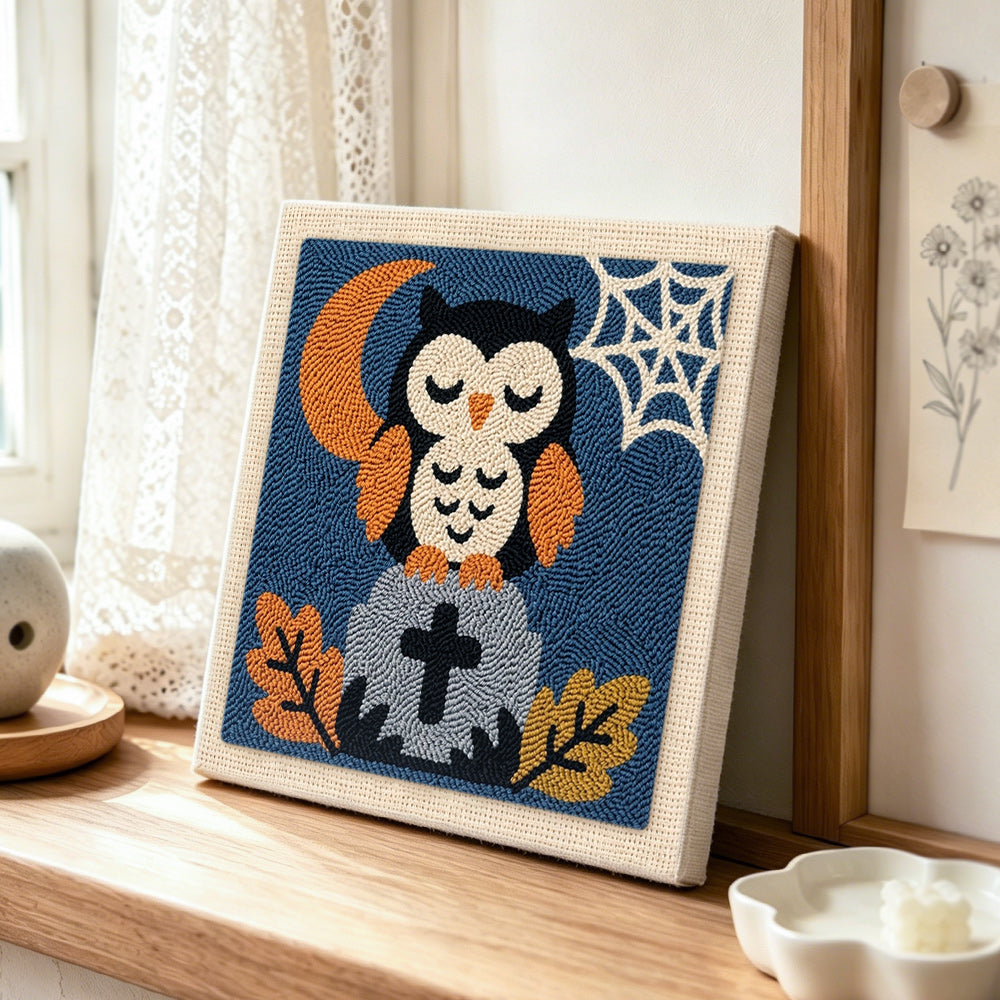Sleepy owl on tombstone punch needle artwork displayed on a table