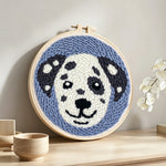 Smiling dog punch needle artwork displayed on a table