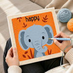 Creating handmade smiling gray elephant punch needle artwork
