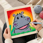Creating handmade smiling gray hippo with rainbow sunset punch needle artwork