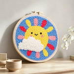 Smiling sun with rainbow rays punch needle artwork displayed on a table