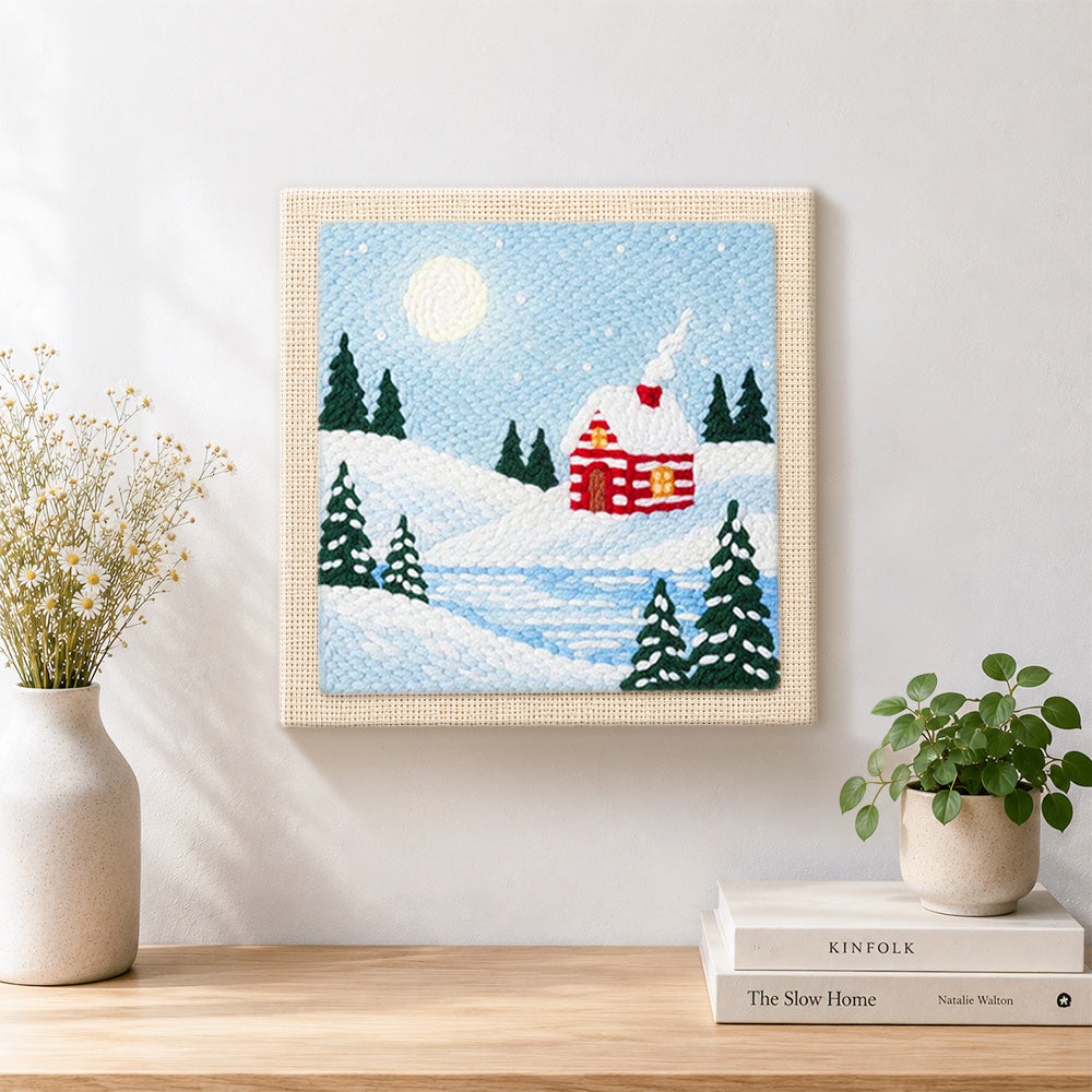 Finished snow cabin in moonlight artwork displayed on a wall