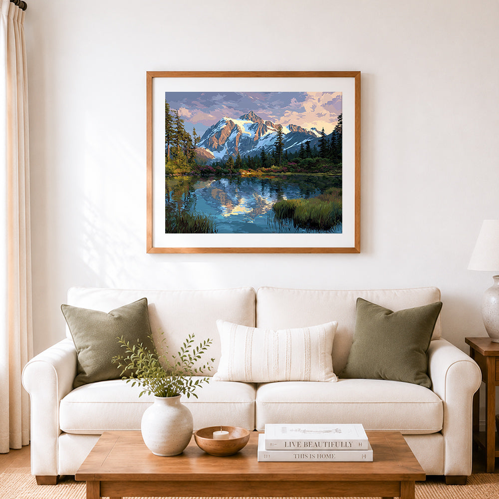 Finished snow-capped mountain reflecting in lake cross stitch artwork displayed as home decor