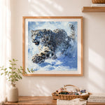 Finished snow leopard in motion cross stitch artwork displayed as home decor
