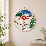 Snowman and christmas tree red cabin needle felt wall art displayed in a bright home interior