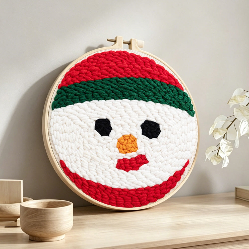 Snowman face punch needle artwork displayed on a table