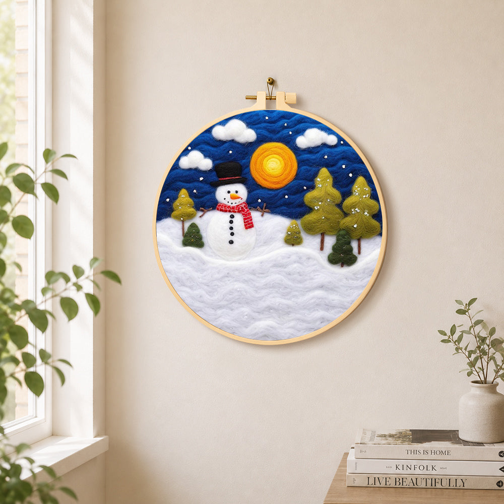 Snowman with red scarf and pine trees needle felt wall art displayed in a bright home interior